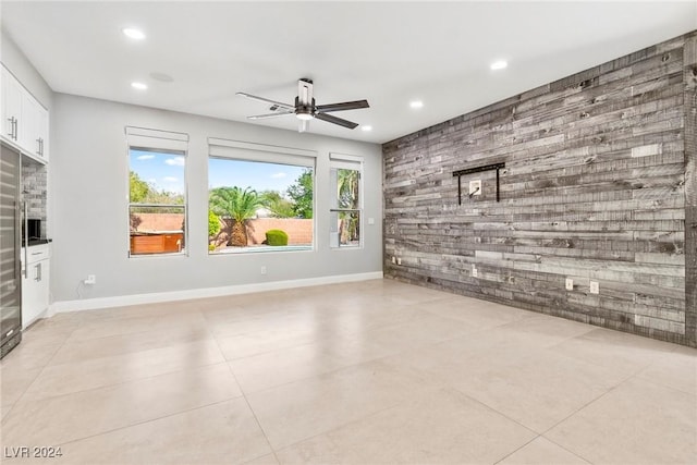 unfurnished living room featuring ceiling fan and light tile patterned floors