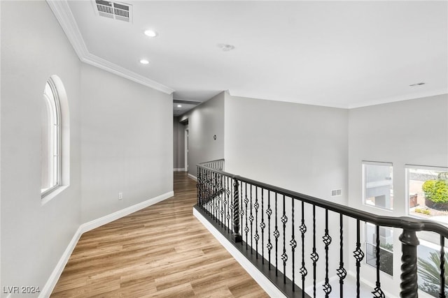 hallway with crown molding and light hardwood / wood-style flooring