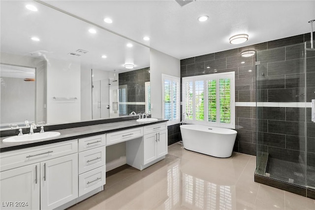 bathroom featuring tile patterned floors, vanity, and shower with separate bathtub