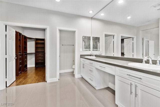 bathroom featuring toilet, vanity, and hardwood / wood-style flooring