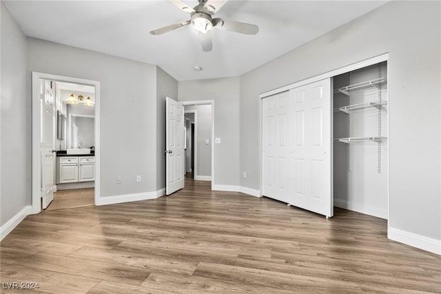 unfurnished bedroom featuring hardwood / wood-style floors, ceiling fan, ensuite bathroom, and a closet