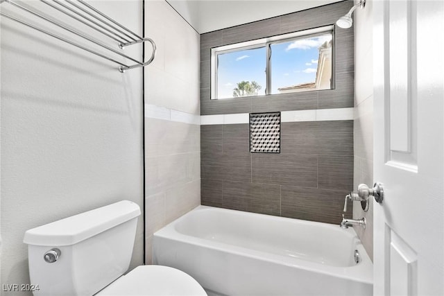 bathroom with tiled shower / bath combo and toilet