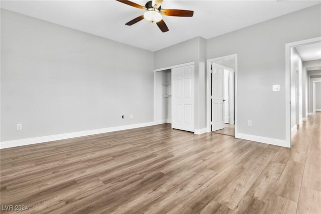 unfurnished bedroom with ceiling fan, a closet, and light wood-type flooring