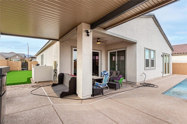 view of patio / terrace with ceiling fan and a fenced in pool