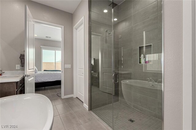 bathroom with tile patterned flooring, vanity, and separate shower and tub