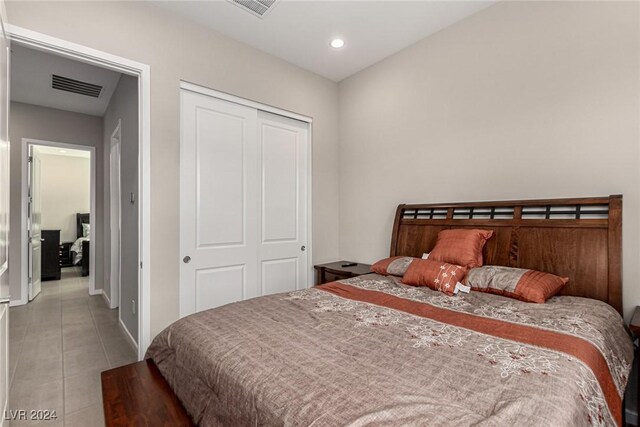 bedroom with tile patterned flooring and a closet