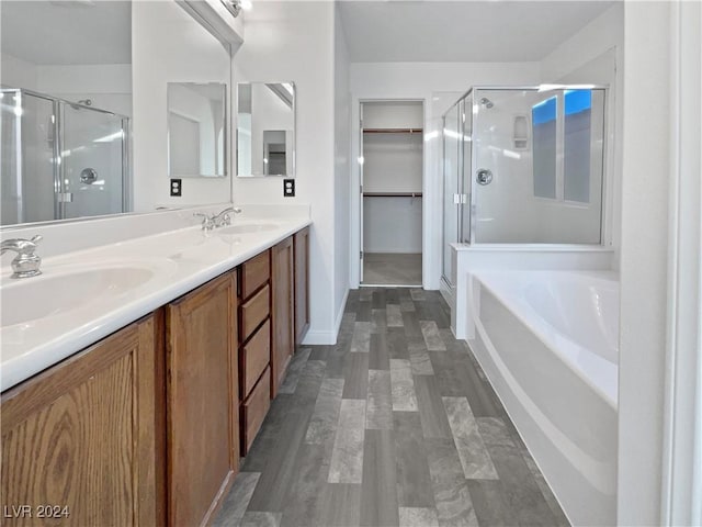 bathroom with independent shower and bath, vanity, and wood-type flooring