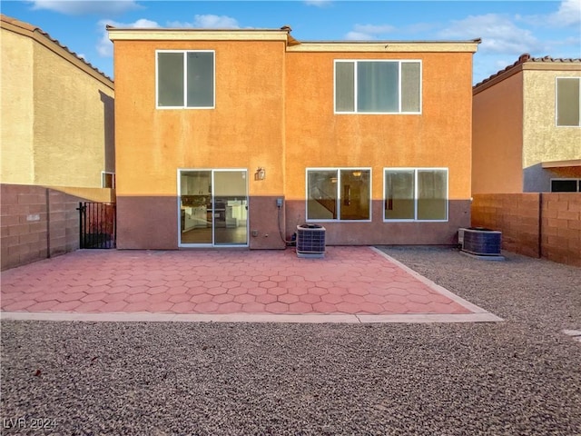 back of property with central AC and a patio area