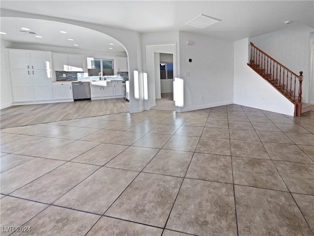 unfurnished living room with light tile patterned floors and sink