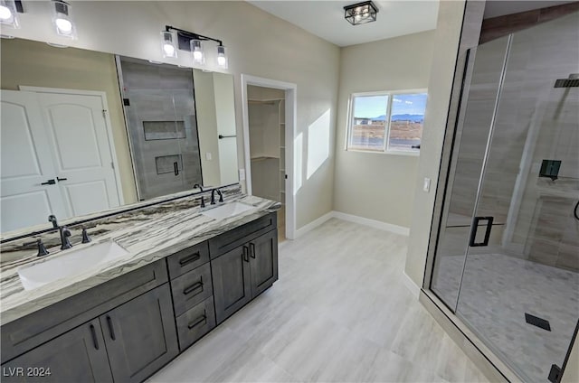 bathroom featuring a shower with door and vanity