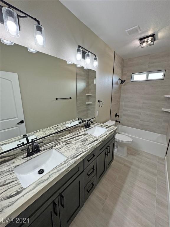 full bathroom featuring tiled shower / bath combo, toilet, and vanity