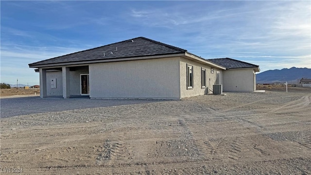 rear view of house with a mountain view and cooling unit