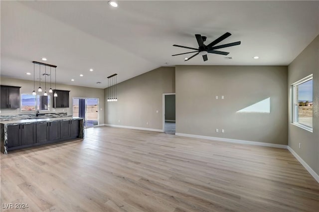 unfurnished living room with ceiling fan, light hardwood / wood-style flooring, lofted ceiling, and sink