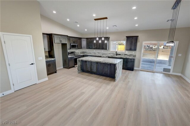 kitchen featuring light hardwood / wood-style flooring, a kitchen island, pendant lighting, and appliances with stainless steel finishes