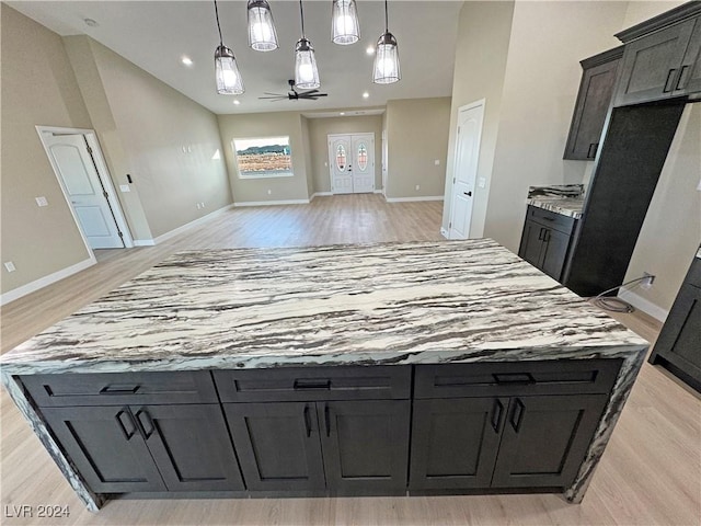 kitchen with a center island, decorative light fixtures, light hardwood / wood-style flooring, and ceiling fan