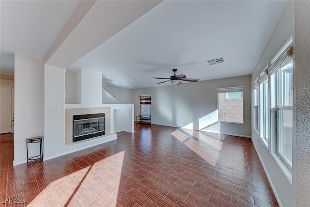 living room featuring a tile fireplace, ceiling fan, and wood-type flooring