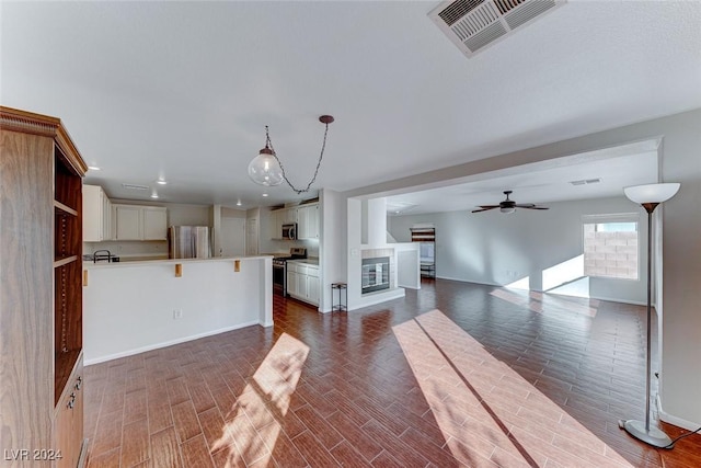 unfurnished living room featuring dark hardwood / wood-style floors and ceiling fan