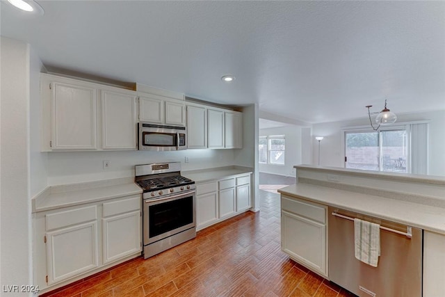 kitchen featuring white cabinets, stainless steel appliances, and light wood-type flooring