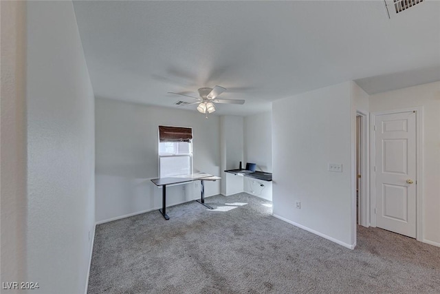 unfurnished office featuring ceiling fan and light colored carpet