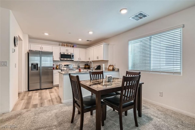 dining space featuring light hardwood / wood-style floors and sink