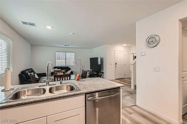 kitchen with white cabinets, sink, stone countertops, dishwasher, and light hardwood / wood-style floors