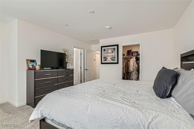 carpeted bedroom with a spacious closet and a closet