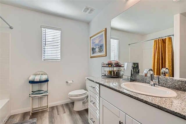 full bathroom featuring shower / bath combo with shower curtain, hardwood / wood-style floors, vanity, and toilet