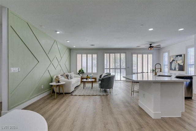 living room with light wood-type flooring, a wealth of natural light, and sink