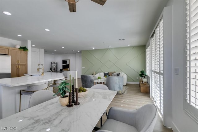 dining space with light wood-type flooring and sink