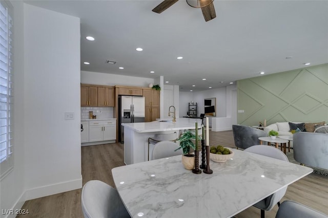 dining space featuring light hardwood / wood-style floors, ceiling fan, and sink