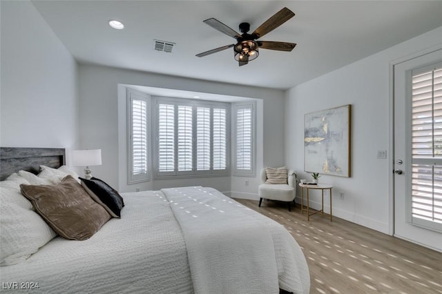 bedroom with multiple windows, ceiling fan, and light hardwood / wood-style floors