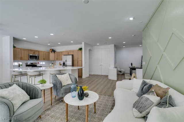 living room with light hardwood / wood-style flooring and sink