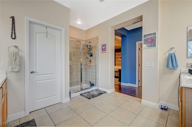 bathroom with tile patterned flooring, vanity, and a shower with shower door