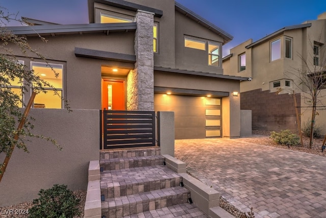 exterior entry at dusk with a garage