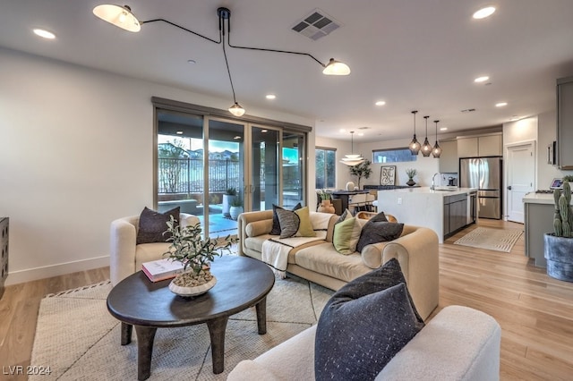 living room featuring light hardwood / wood-style floors and sink