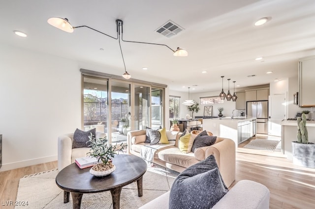 living room with sink and light wood-type flooring