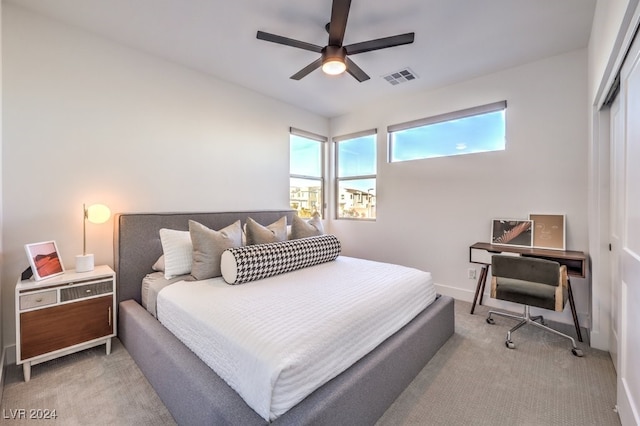 carpeted bedroom with ceiling fan and a closet