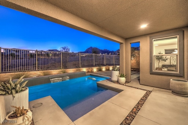 pool at dusk featuring a patio