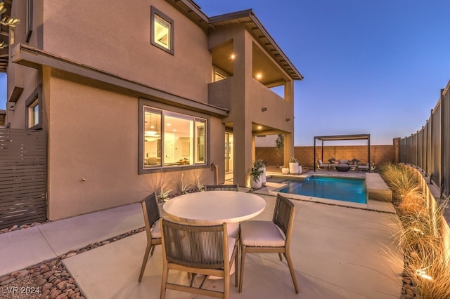 pool at dusk featuring a patio