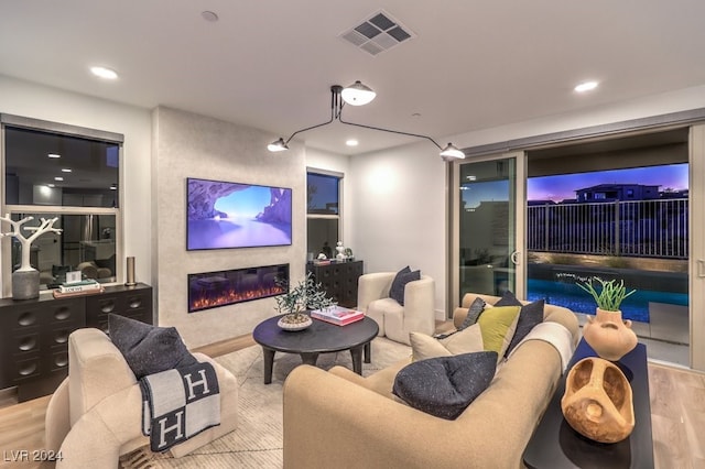 home theater with a large fireplace and light hardwood / wood-style floors