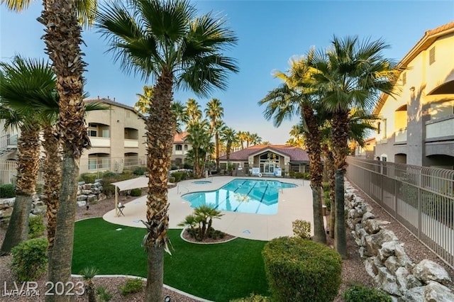 view of pool with a patio area and a yard