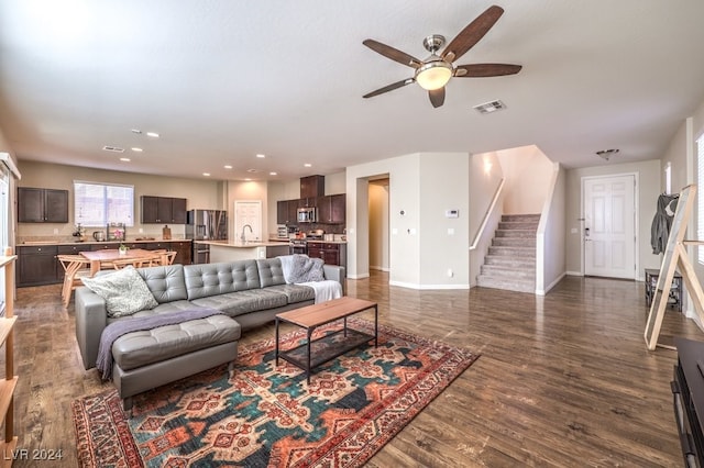 living room featuring dark hardwood / wood-style floors, ceiling fan, and sink