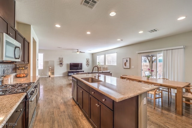 kitchen featuring a center island with sink, a healthy amount of sunlight, sink, and appliances with stainless steel finishes