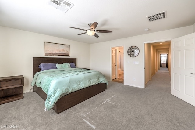 bedroom featuring ensuite bath, ceiling fan, and light carpet