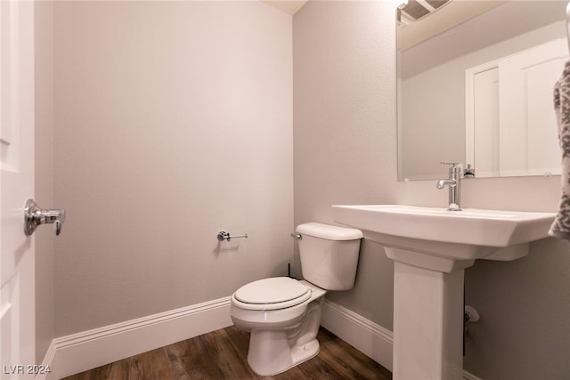 bathroom featuring wood-type flooring and toilet