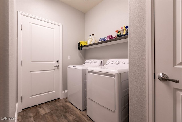 laundry room with washer and dryer and dark wood-type flooring