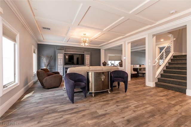 living room featuring hardwood / wood-style flooring, an inviting chandelier, ornamental molding, and coffered ceiling