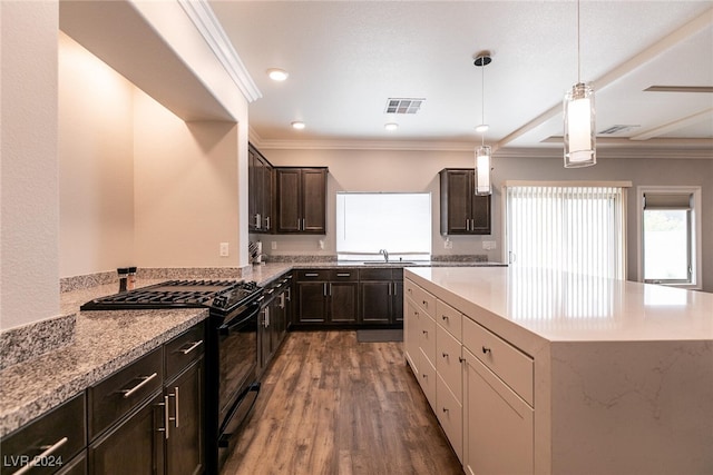 kitchen featuring gas stove, sink, dark wood-type flooring, decorative light fixtures, and ornamental molding