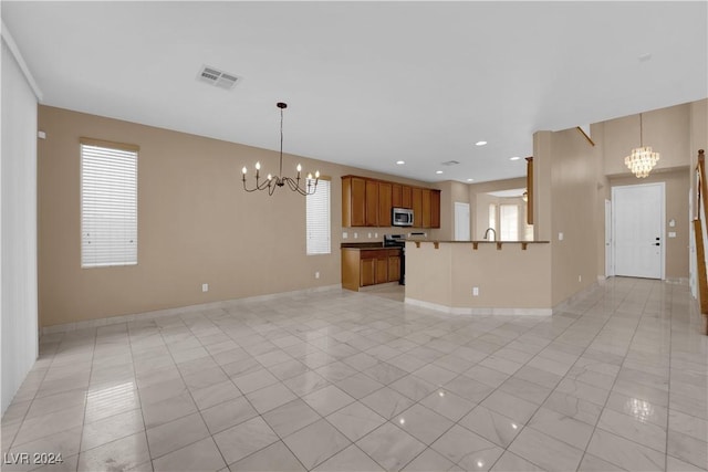 interior space with kitchen peninsula, a chandelier, light tile patterned floors, and pendant lighting