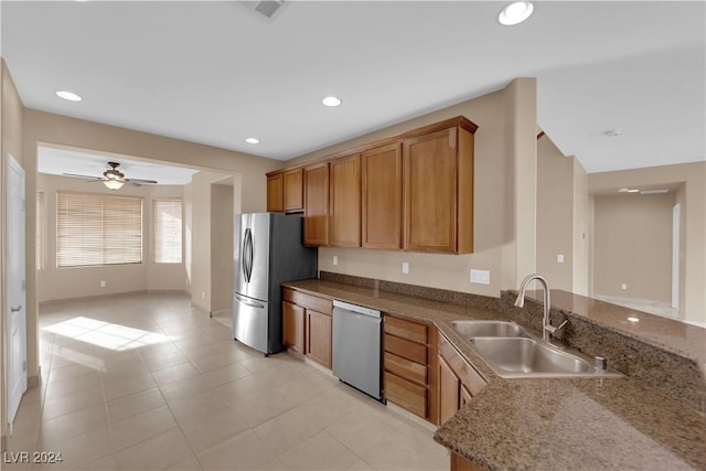 kitchen with stone counters, sink, ceiling fan, light tile patterned floors, and stainless steel appliances